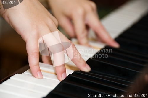 Image of hands on keys of a piano