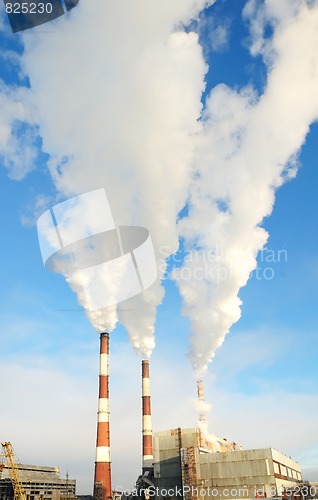 Image of three smoking chimneys of power plant