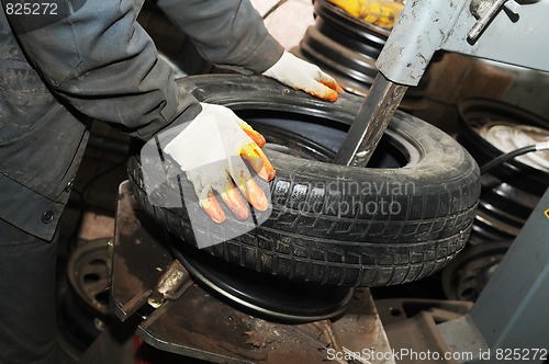 Image of taking off tyre from car wheel disc