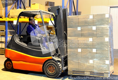 Image of worker and forklift loader at warehouse