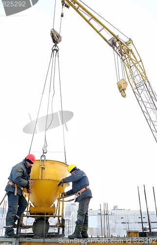 Image of building workers pouring concrete in form