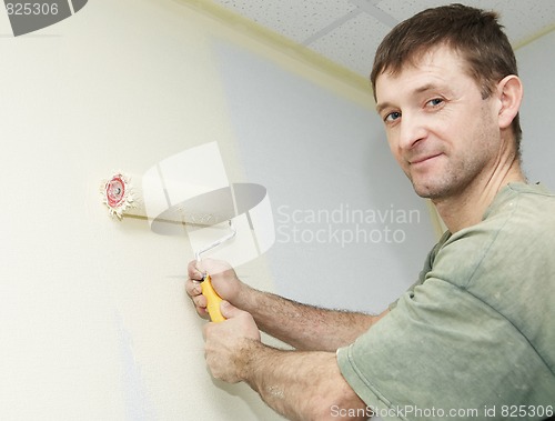 Image of Painter worker with roller at work