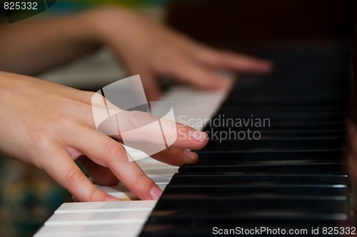 Image of hands on keys of a piano