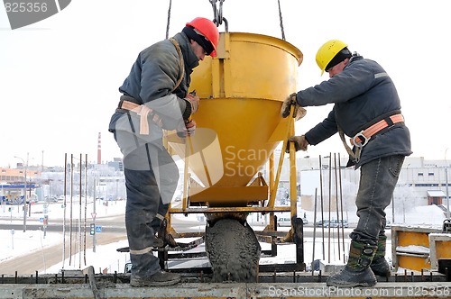 Image of construction workers pouring concrete in form