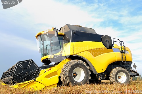 Image of combine harvester during field work on farm