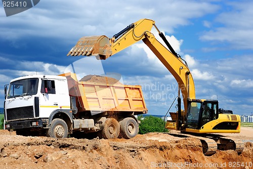 Image of Excavator loading dumper truck