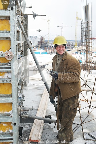 Image of worker with hammer assembling formwork