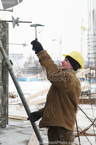 Image of worker with hammer assembling formwork