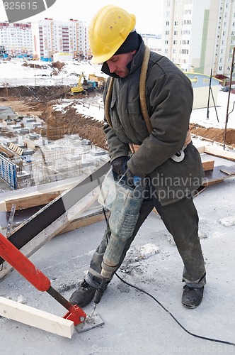 Image of worker builder drill and concrete formwork