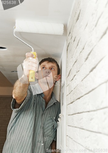 Image of Painter worker painting a ceiling