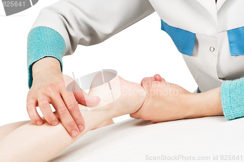 Image of Masseur massaging a child leg