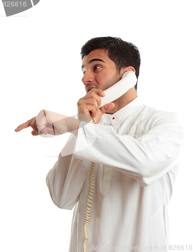 Image of Ethnic businessman on phone pointing