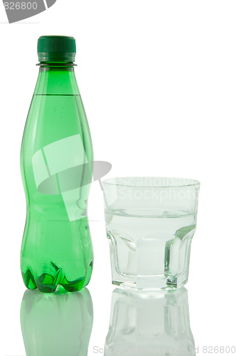 Image of Bottle and glass of mineral water reflected on white background