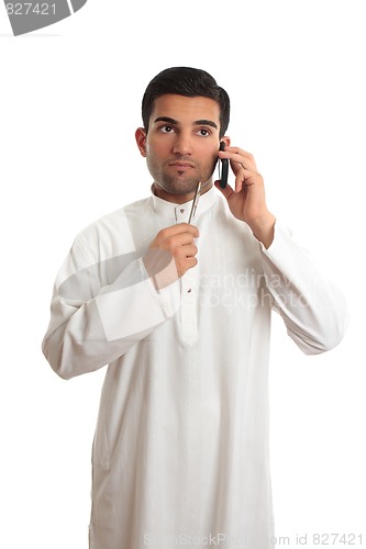 Image of Thinking ethnic businessman on mobile phone