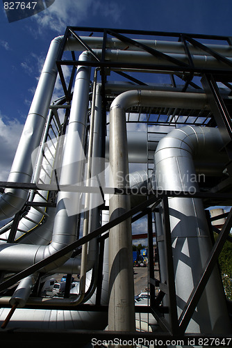 Image of  industrial pipelines and cables against blue sky