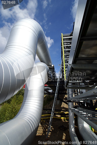 Image of industrial pipelines and cables against blue sky