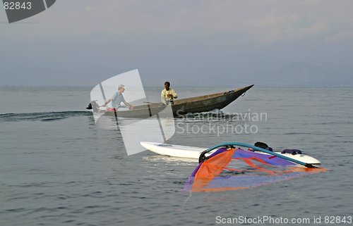 Image of traditional fishing boat and windsurfer