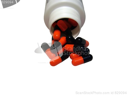 Image of Multicolored capsules out of the bottle on white