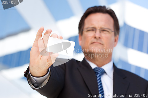 Image of Handsome Businessman Holds Out Blank Business Card