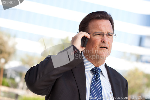 Image of Concerned Businessman Talks on His Cell Phone