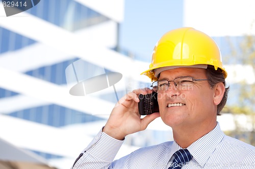 Image of Contractor in Hardhat and Necktie Talks on His Cell Phone