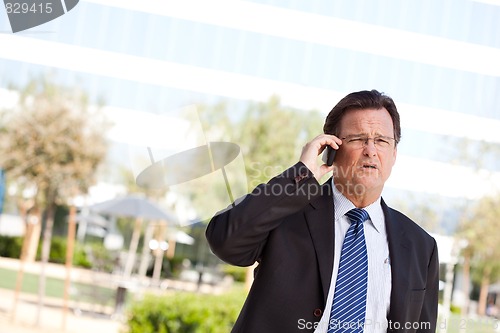 Image of Concerned Businessman Talks on His Cell Phone