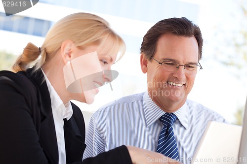 Image of Businessman and Female Colleague Using Loptop Outdoors