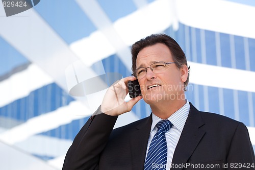 Image of Businessman Smiles as He Talks on His Cell Phone