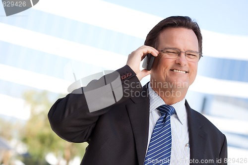 Image of Businessman Smiles as He Talks on His Cell Phone