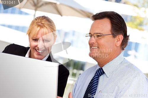 Image of Businessman and Female Colleague Using Loptop Outdoors