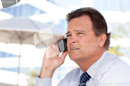 Image of Businessman Smiles as He Talks on His Cell Phone