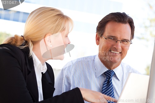 Image of Businessman and Female Colleague Using Loptop Outdoors