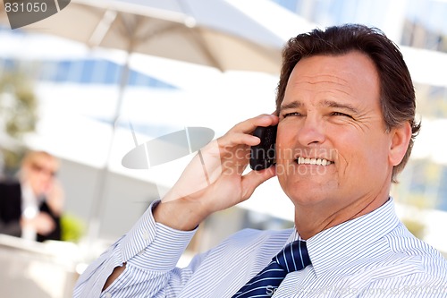 Image of Businessman Smiles as He Talks on His Cell Phone