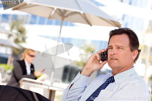 Image of Businessman Smiles as He Talks on His Cell Phone