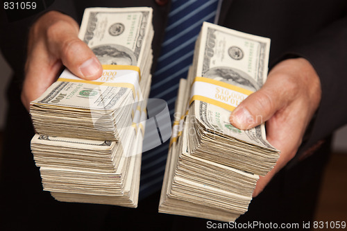 Image of Businessman Handing Over Stacks of Money