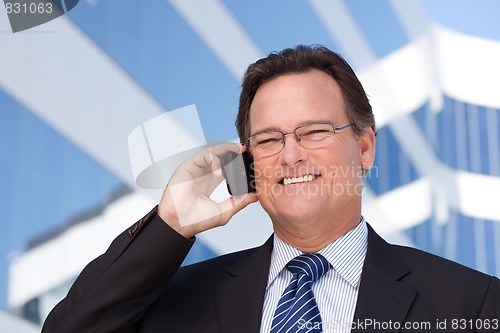 Image of Businessman Smiles as He Talks on His Cell Phone