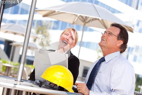 Image of Businesswoman and Man Laughing While Working