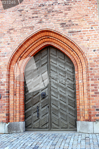 Image of Old wooden doors in a brick wall