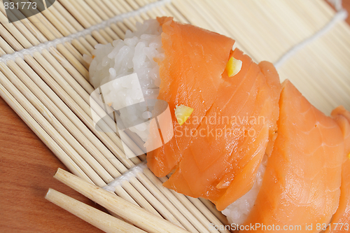 Image of Salmon sushi on bamboo mat