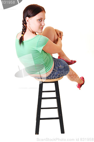 Image of Pretty girl sitting on bar chair.
