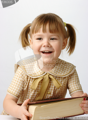 Image of Happy little girl with book, back to school