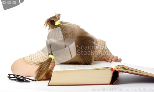 Image of Little girl is sleeping on book, back to school