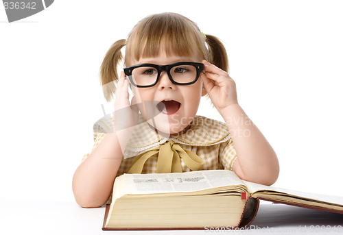 Image of Happy little girl with book, back to school
