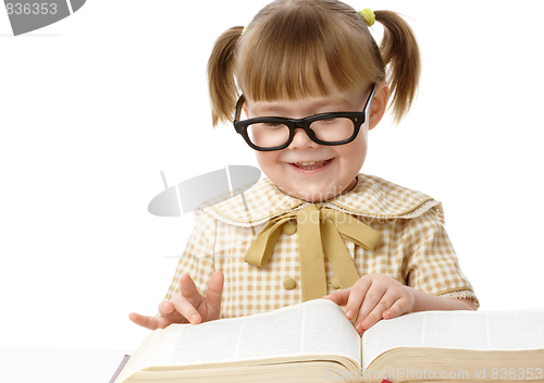 Image of Cute little girl reads book, back to school