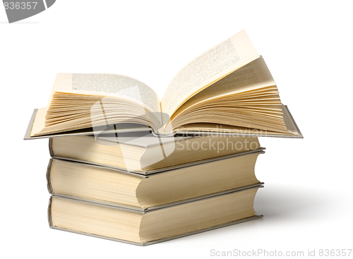 Image of A pile of books, top one is open