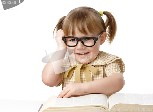 Image of Happy little girl with books wearing black glasses