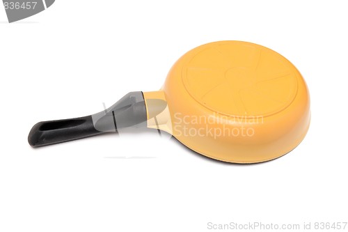 Image of Black and yellow frying pan upside down isolated 