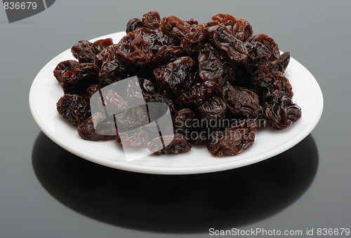 Image of Raisin on a white plate on a black background