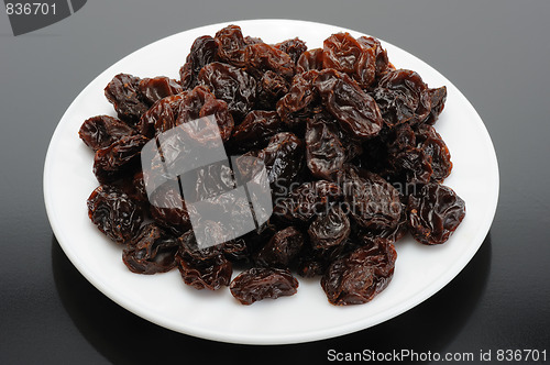 Image of Raisin on a white plate on a black background
