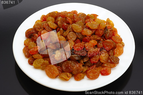 Image of Raisin on a white plate on a black background